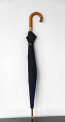 Typical black umbrella closed and isolated on white background