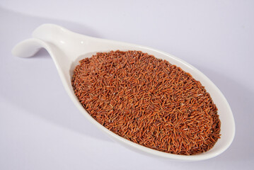 Close up of red rice grains in a white dish, healthy food ingredient.