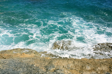 Ocean waves hitting rocks, sea foam, beach