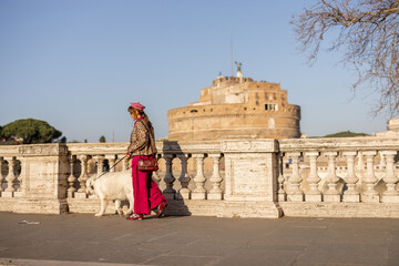 A woman embraces her dog on a Roman bridge with Castel SantAngelo in the background. This photo...