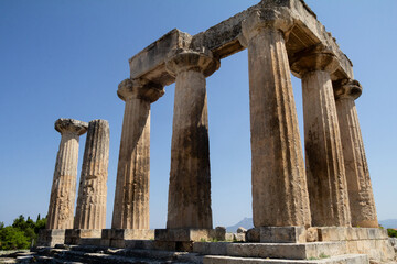 Fototapeta premium Showcase the remnants of ancient Greek architecture, such as columns and stone structures, set against the backdrop of the Mediterranean landscape.