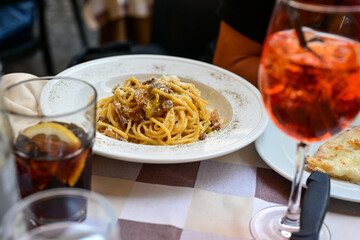 Fresh pasta   spaghetti  carbonara and Aperol Spritz  at  typical italian resaturant at Trastevere ...