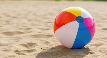A colorful beach ball resting on the sandy shore under the bright sunlight of a summer day scene