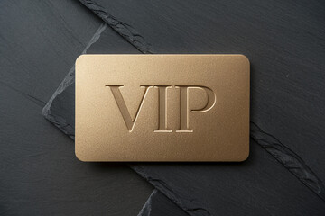 Gold VIP card on dark slate background, showcasing exclusivity and premium status, ideal for luxury branding or membership programs