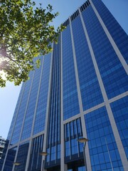 Obraz premium Blue glass skyscraper on a sunny summer day.