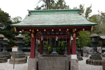 Traditional Japanese Temple Structure with Bell, Lanterns, and Serene Garden Setting in the Background