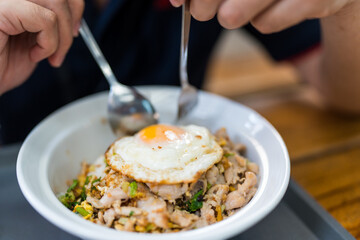 Man eating Steamed pork on rice and fried egg. Close up