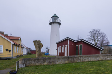 White lighthouse and red wooden house in Smygehuk, Sweden.