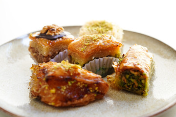 Pistachio, walnut and various other types of baklava on white background	