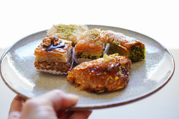 Woman  serving Pistachio, walnut and various other types of baklava