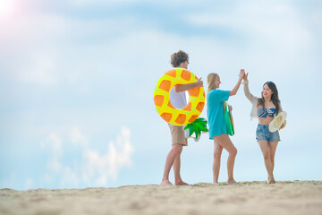 Group of millennial travelers embracing the beach spirit with laughter and inflatable floats. Captures the essence of joy and summer freedom.
