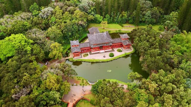 Rising over Byodo-In Temple at the foot of the Koolau Mountains in Valley of the Temples Memorial Park. Beautiful landmark surrounded by the lush greenery. Oahu, Hawaii, USA.