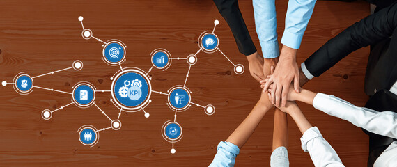 Dynamic teamwork depicted over a wooden table, showcasing hands connected while KPI icons symbolize...