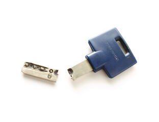 Broken key from home. Large long key snapped in two. House key for residential building. Locksmith or handyman needed for lock malfunction or key replacement. Selective focus. White background.