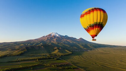 Yellow Hot Air Balloon Soaring Over Autumnal Mountain Landscape at Sunrise