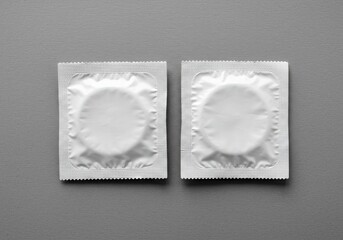 Two condom mockup on gray background for sexual health and disease prevention product presentation and advertising