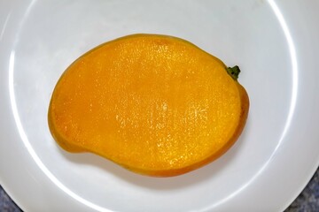 Ripe rosa mango isolated on uniform background. Brazilian fruit and food