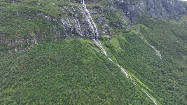 Drone view of the waterfall of Vikagjolet Fossen streaming on green mountain in Loen