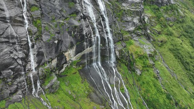 Drone view of the waterfall of Vikagjolet Fossen streaming on moss-covered rocks in Loen