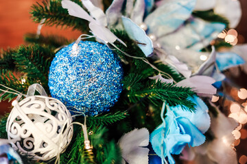 Decorative blue and silver ornaments on holiday greenery in festive decor setting
