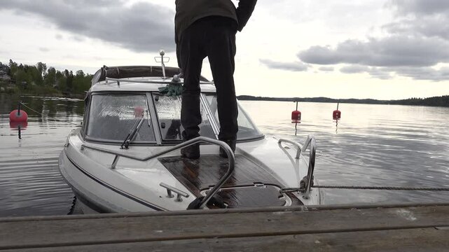 Stockholm, Sweden A man mops and cleans a motorboat at a dock in Lake Malaren. 