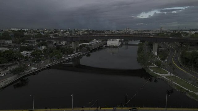 Drone flies over the Floating Bridge and the Juan Pablo Duarte Bridge on cloudy afternoon in Santo Domingo, Dominican Republic