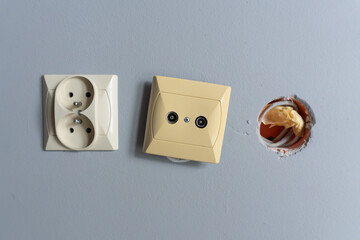 A close-up view of an unfinished electrical installation, featuring a dual wall socket, a TV or...