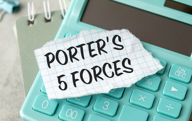 A calculator sits on a desk with a piece of paper that says Porter's 5 Forces