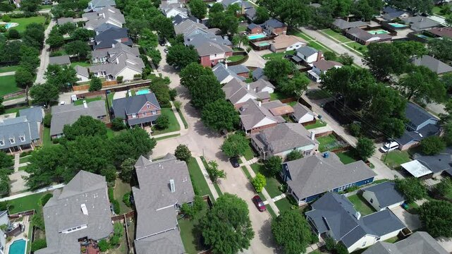 Suburban expensive two-story mansion home on extra-large lot backyard in Carrollton, suburbs Dallas Fort Worth Metroplex, upscale lush green tree lined street, wooden fence, grassy yard, flyover