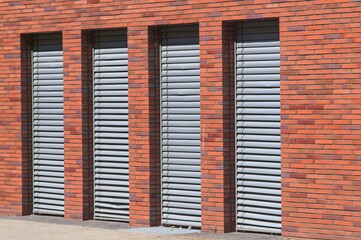 Modern brick wall with closed venetian blinds creating repeating pattern