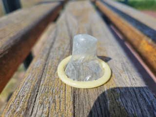 Closeup on unused condom on wooden board.