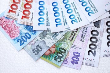 Argentine pesos money bills in big amount lies on white table close up
