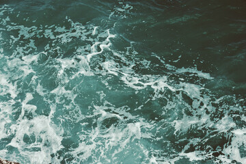 Turbulent ocean waves with white foam patterns in deep blue waters