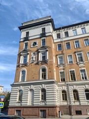 An old European-style building showcasing intricate stonework, arched windows, and a detailed sculptural element. This image symbolizes forgotten grandeur in urban landscapes.