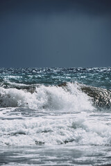 Majestic ocean wave crashing on shore under moody sky with natural details