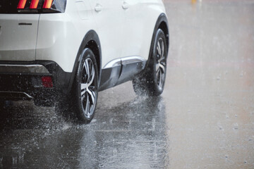 White car driving on wet road in heavy rain: dynamic motion and urban transportation scene
