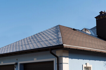 Snow and dry parts of a bitumen roof at dawn