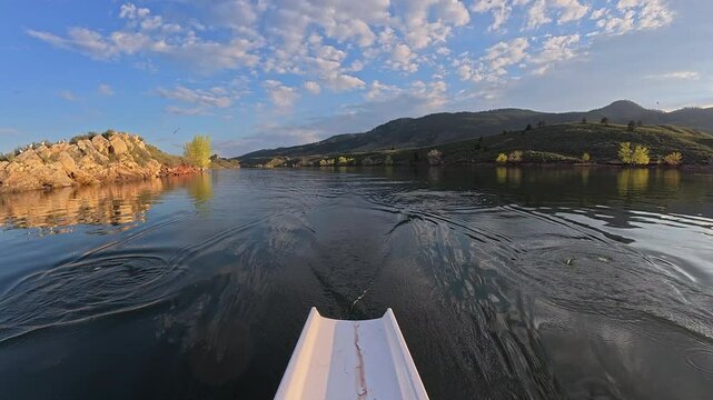 rowing on calm water of  Horsetooth Reservoir in Colorado - springtime scenery, POV rower perspective