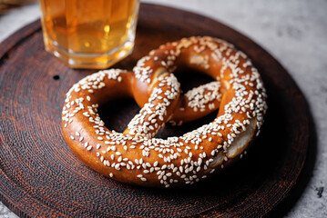 Pretzel with sesame seeds on a grey background
