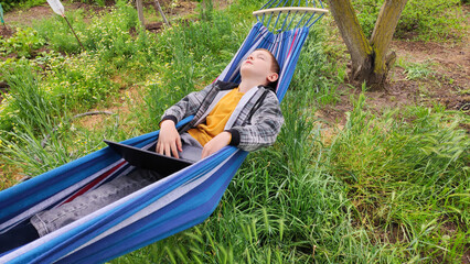 Boy relaxing on picnic during school holidays, family outdoor recreation, camping, summer school holidays. Online learning during holidays