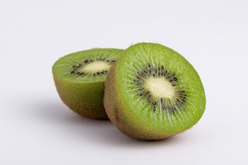 Fototapeta premium Two juicy kiwi fruit halves on a white background.