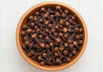 Fototapeta premium Close-Up of Organic Brown Clove Spice in Wooden Bowl for Cooking and Herbal Use