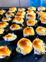 Cooked handcrafted sushi in kitchen. Amateur-made sushi rolls.