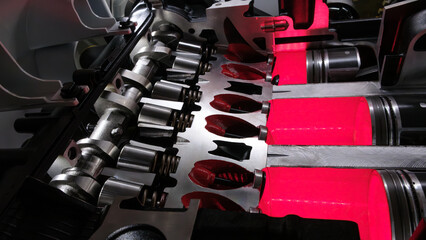 A close up of a car engine with the pistons and valves clearly visible. engine is in the process of...