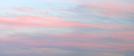 Fototapeta premium A beautiful pink and blue sky with clouds. The sky is a mix of pink and blue, with the pink being more dominant. The clouds are scattered throughout the sky, with some being larger