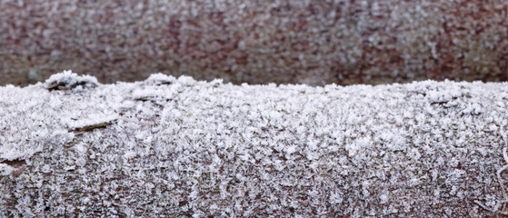 Wooden log with bark covered with frost as texture background for web banner page template