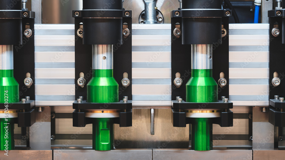 Poster a machine with four green cylinders on it. the cylinders are all the same size and shape, and they a