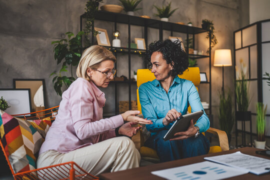 two women work on project at home use digital tablet have consultation