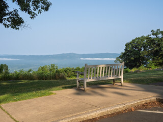Obraz premium Bench lit by the setting sun overlooking the Shenandoah Valley at the Dickey Ridge Visitor Center in Shenandoah National Park, Virginia, USA.