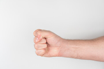 Close-up view of a persons arm in a short-sleeved garment, with a clenched fist Light skin tone...